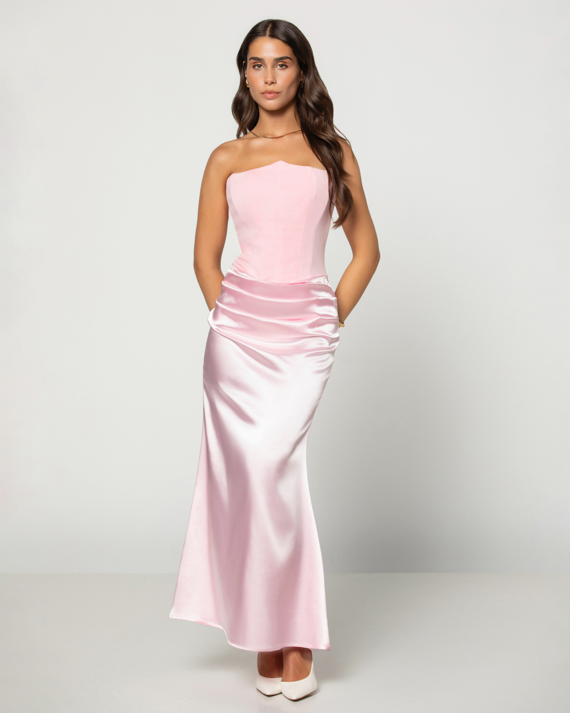 Woman wearing a strapless pink dress on a white background